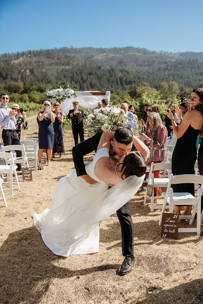 First responders bride and groom sharing first kiss in Napa Valley wedding